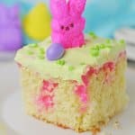close up of a slice of easter poke cake on a white plate