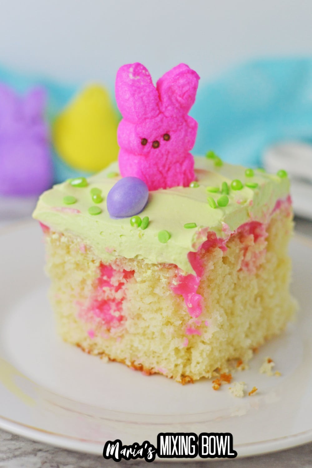 close up of a slice of easter poke cake on a white plate