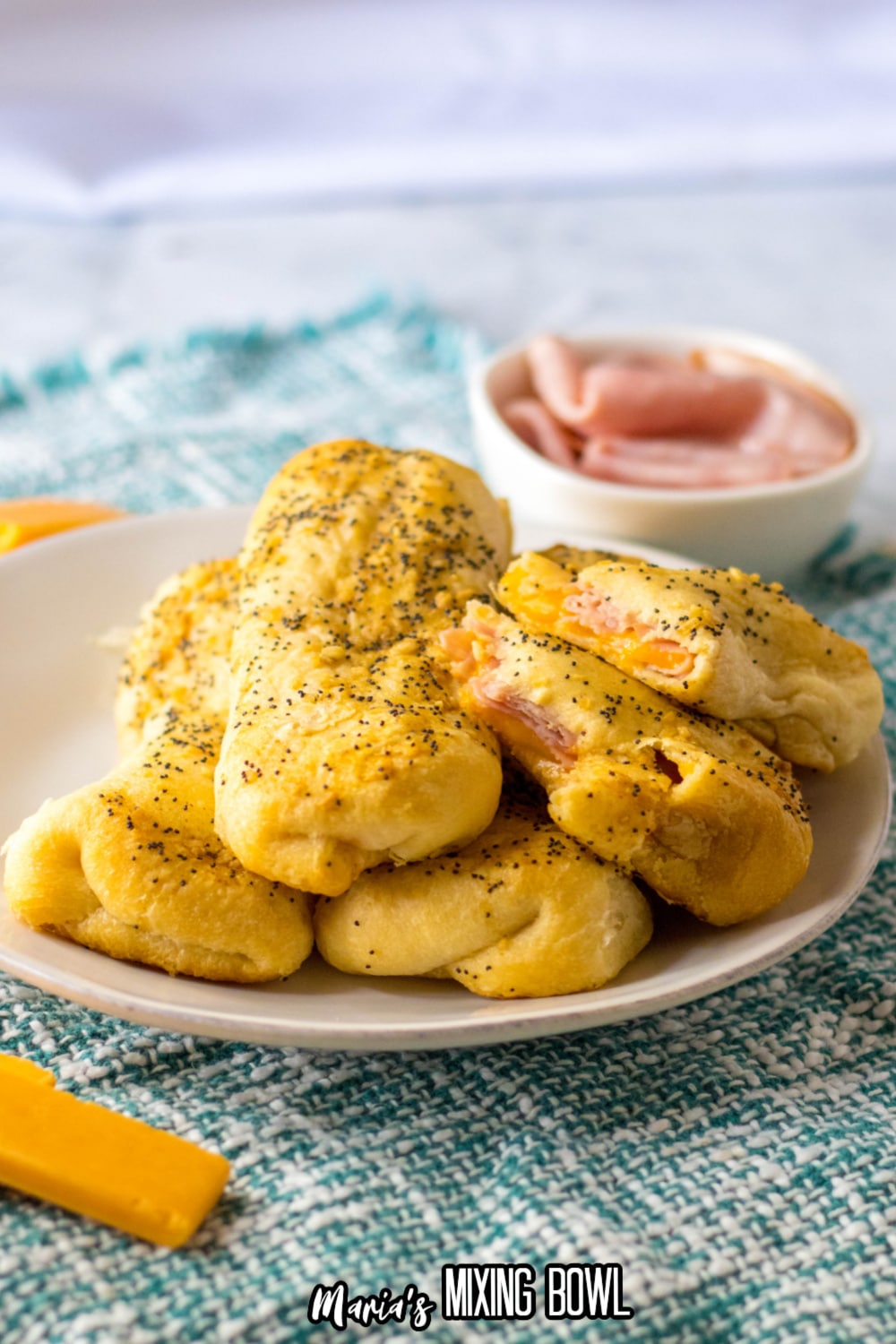 ham and cheese sticks stacked on a white plate