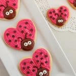 three love bug cookies on a white platter