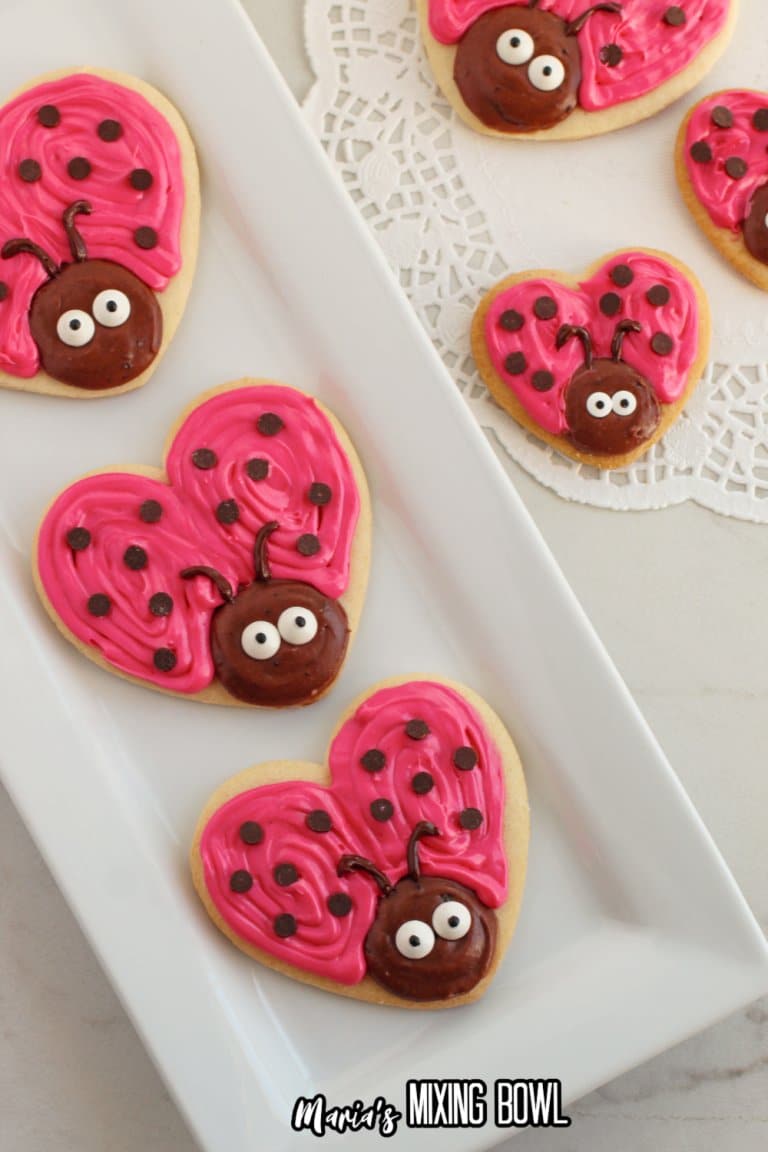 three love bug cookies on a white platter