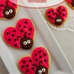 three love bug cookies on a white platter with the name in text for pinterest