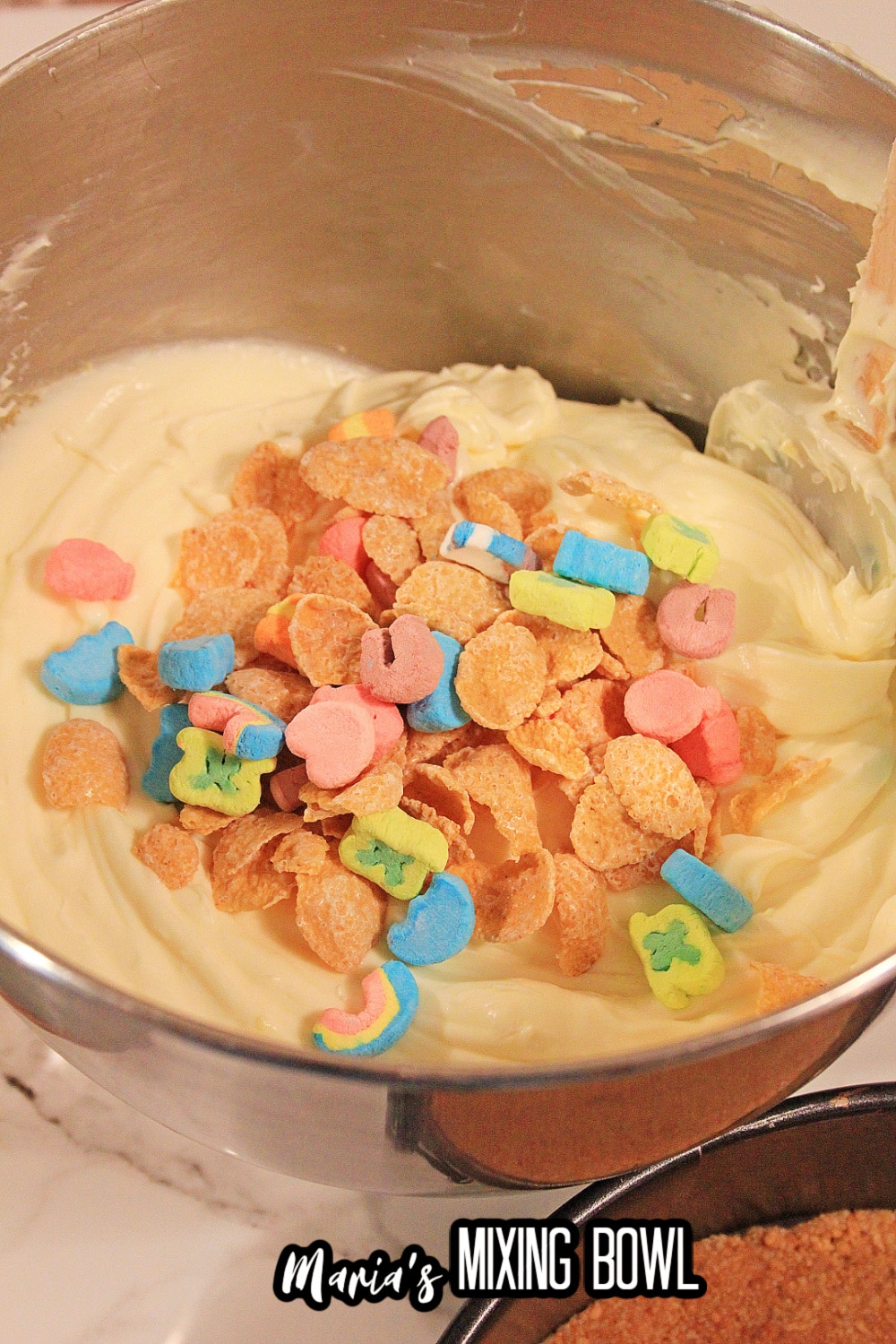 lucky charms cereal being added to cheesecake batter
