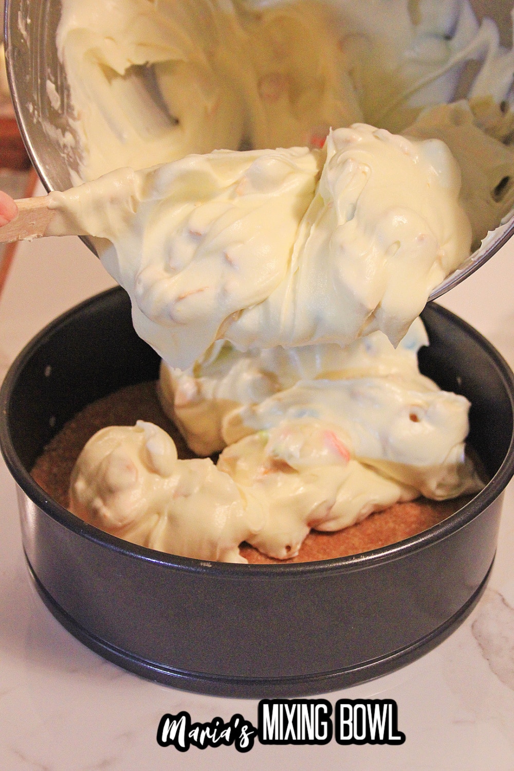 batter being poured into a crust in a springform pan