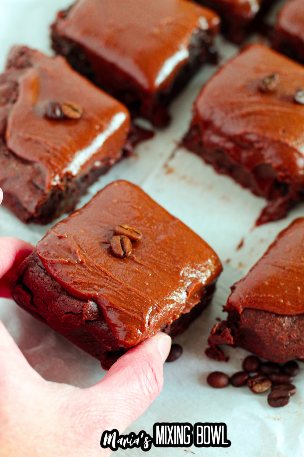 slice of brownie being removed from a pan by a woman's hand.