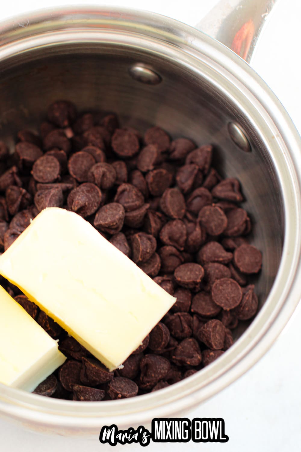 chocolate and butter being melted in a stainless steel pot