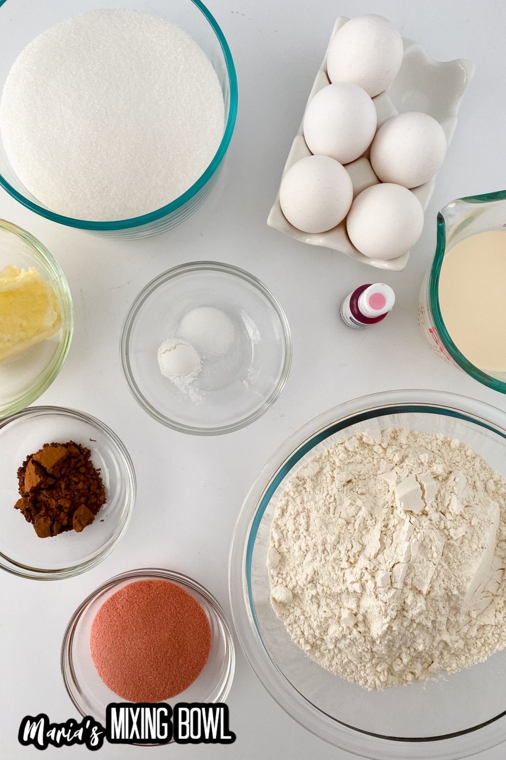 flour, sugar, eggs, milk, butter, cocoa powder, and jello mixture on a white backdrop