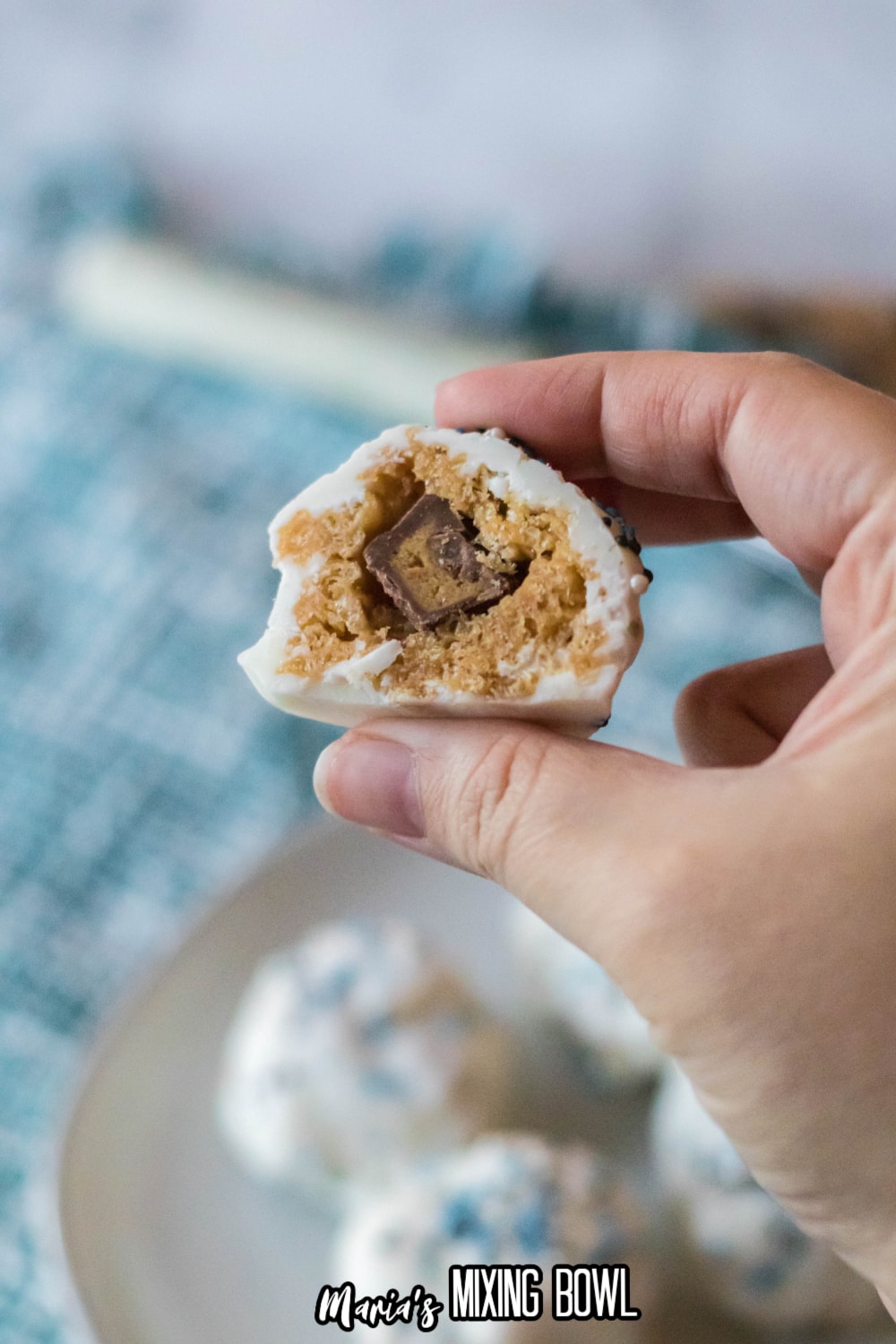 peanut butter ball cut in half held in the air in a women's fingers