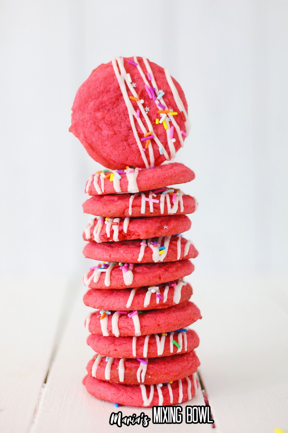 stack of 11 pink velvet cookies on a white wooden background