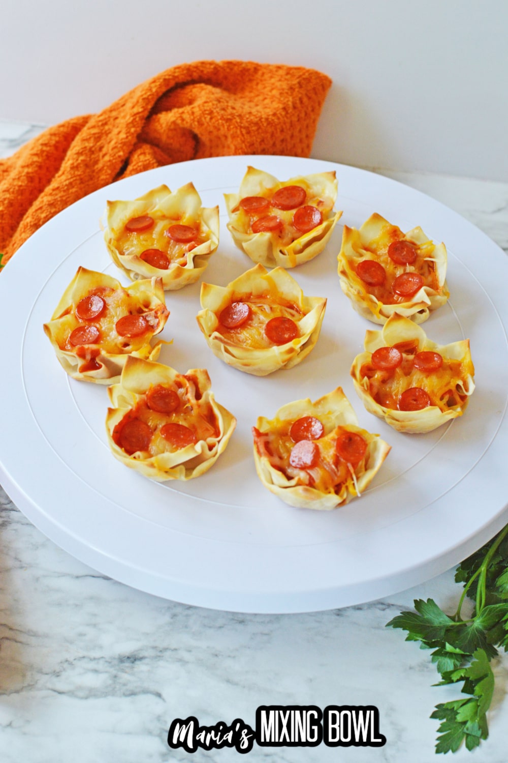 seven pizza wonton cups on a white cake stand