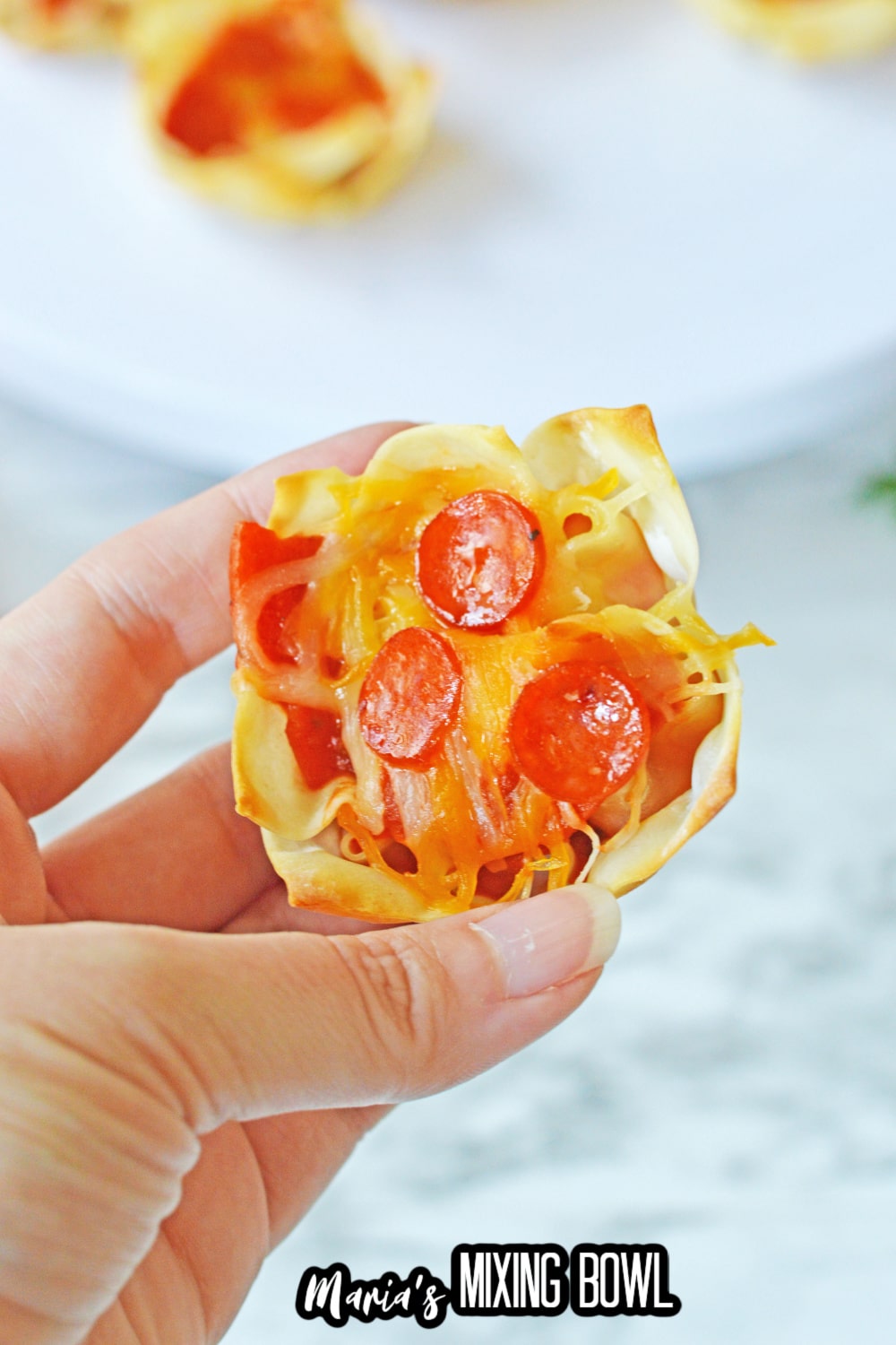 single pizza wonton cups held in a woman's hand