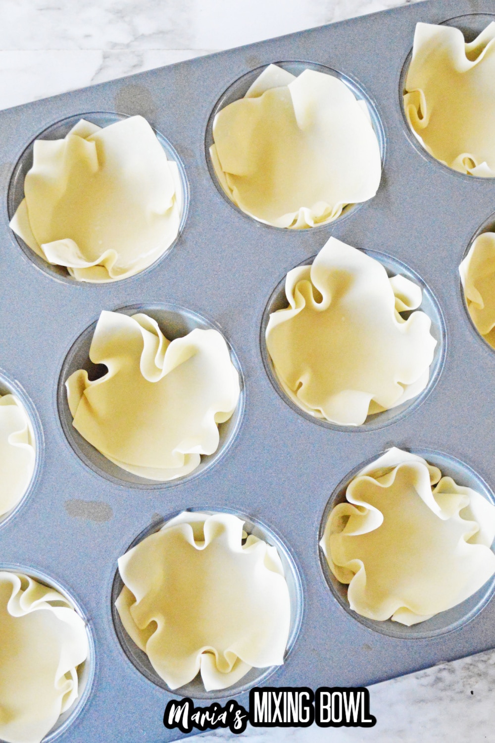 dough pressed into a muffin cup