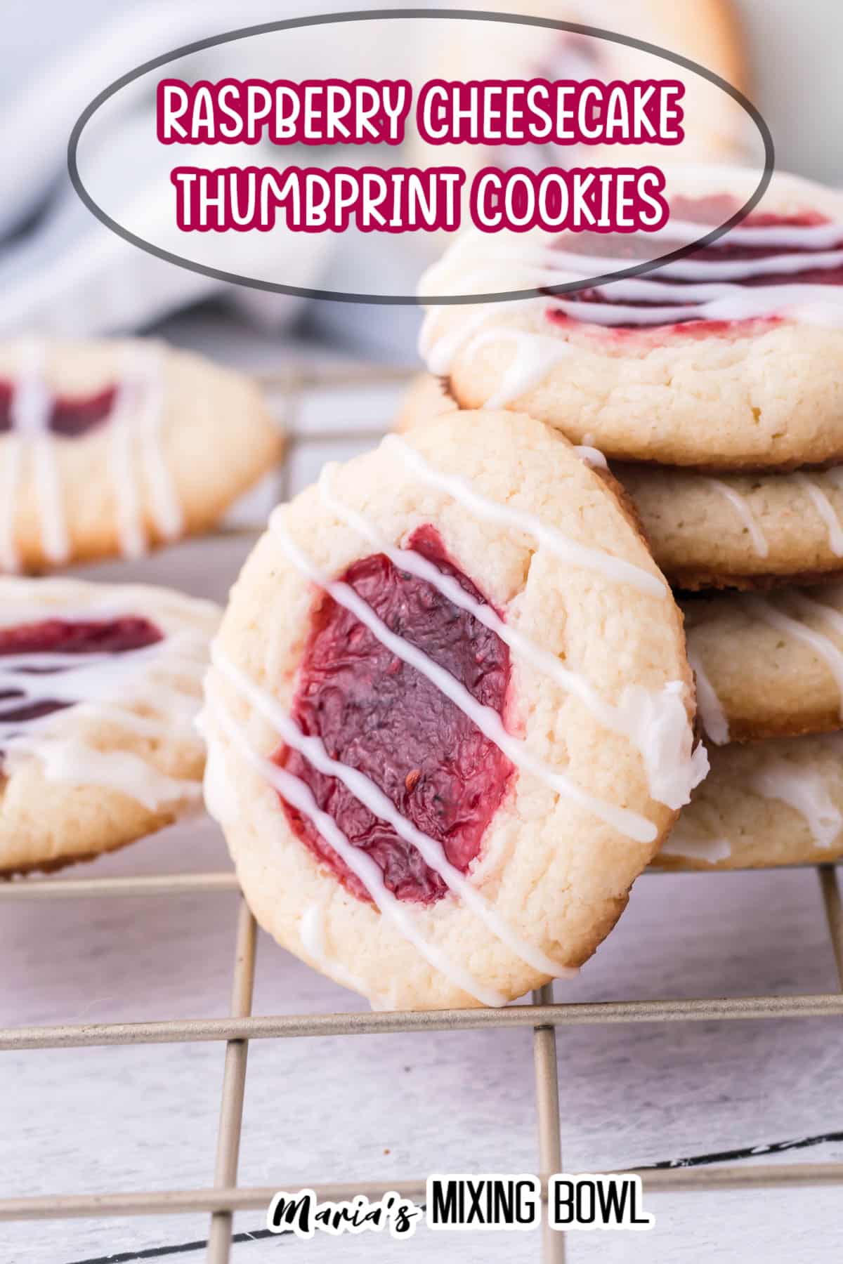 stack of raspberry cheesecake thumbprint cookies with one cookie on it's side leaning against the others