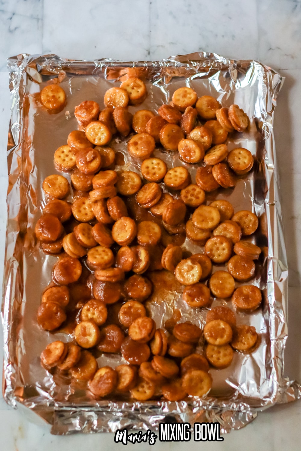 crackers topped in cinnamon sugar on a foil lined baking dish