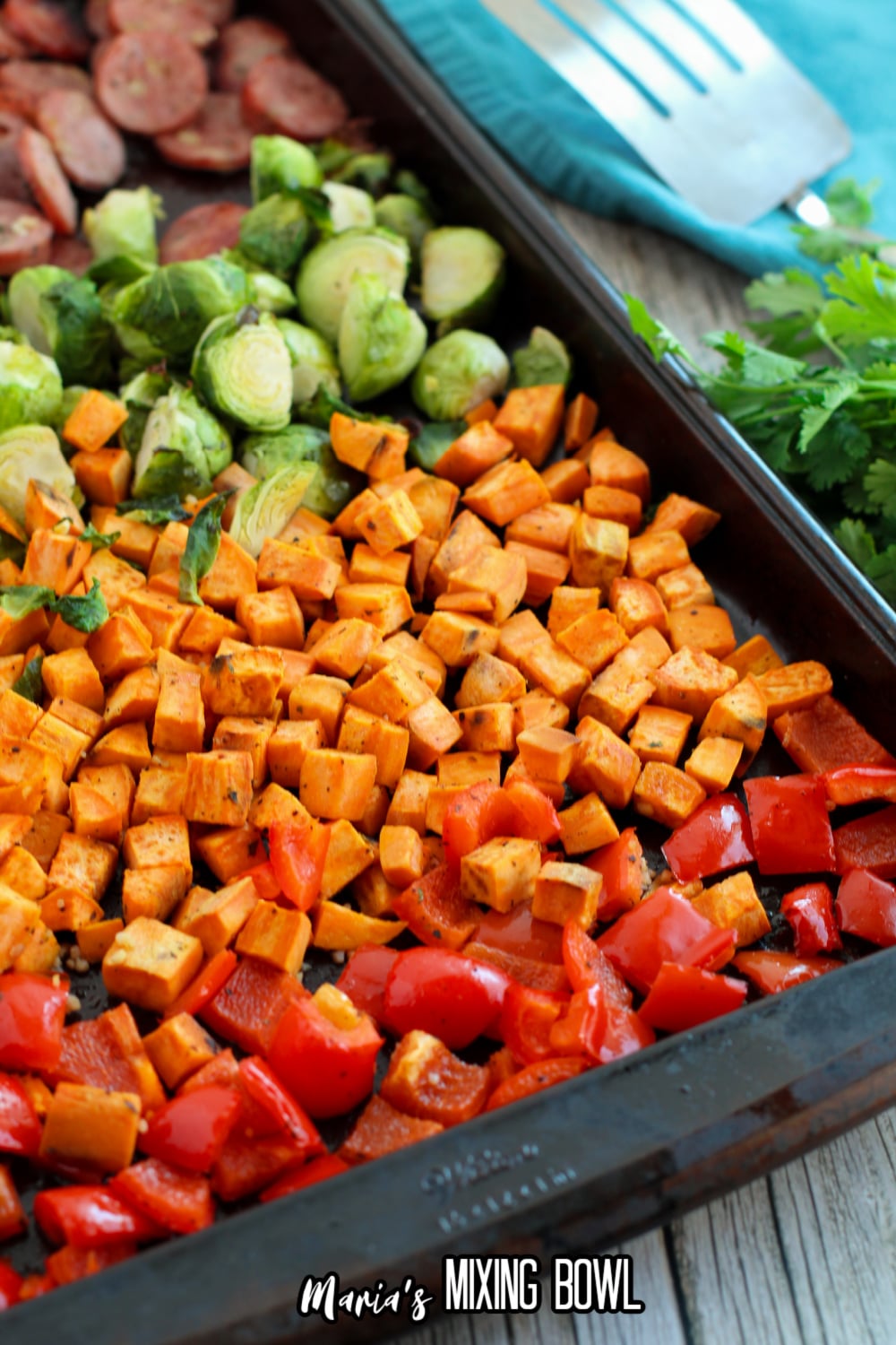 sausage, brussel sprouts, sweet potatoes and peppers on a sheet pan