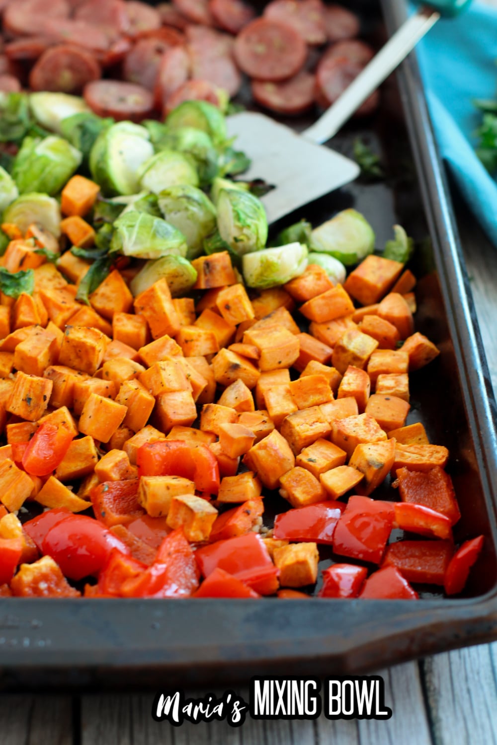 sausage, brussel sprouts, sweet potatoes and peppers on a sheet pan