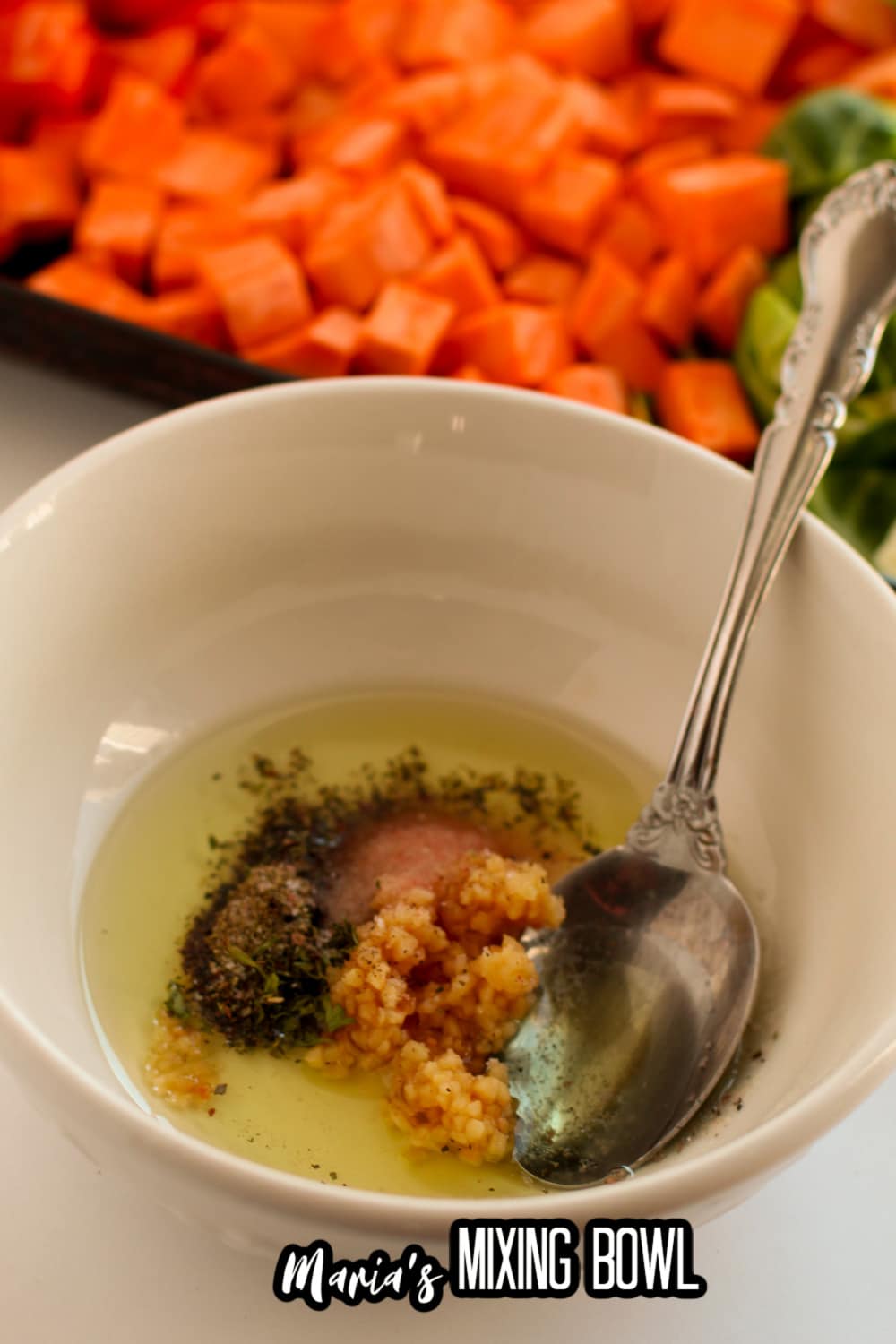 oil and seasoning in a small white bowl with a spoon
