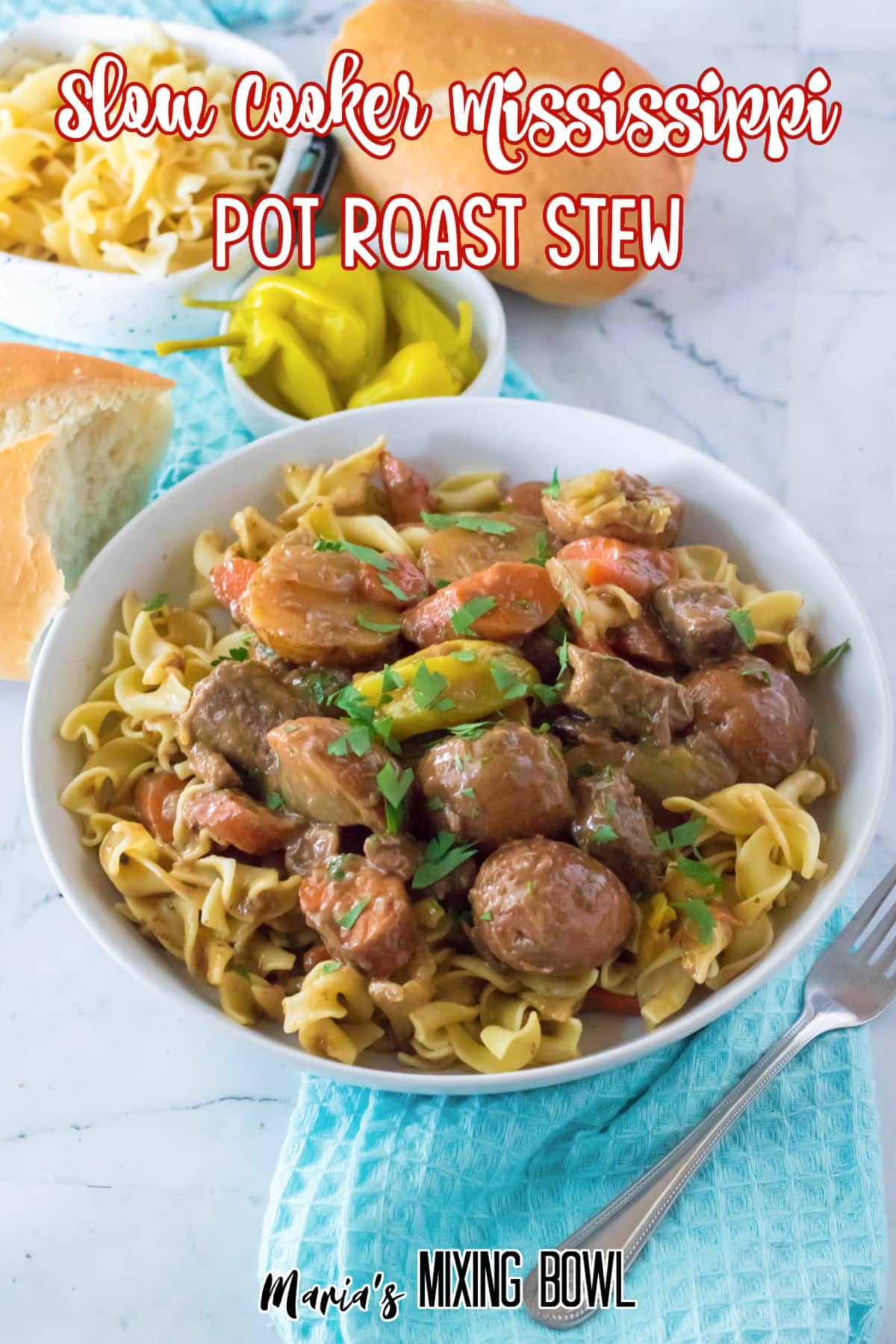 white bowl filled with egg noodles topped with slow cooker Mississippi beef stew.