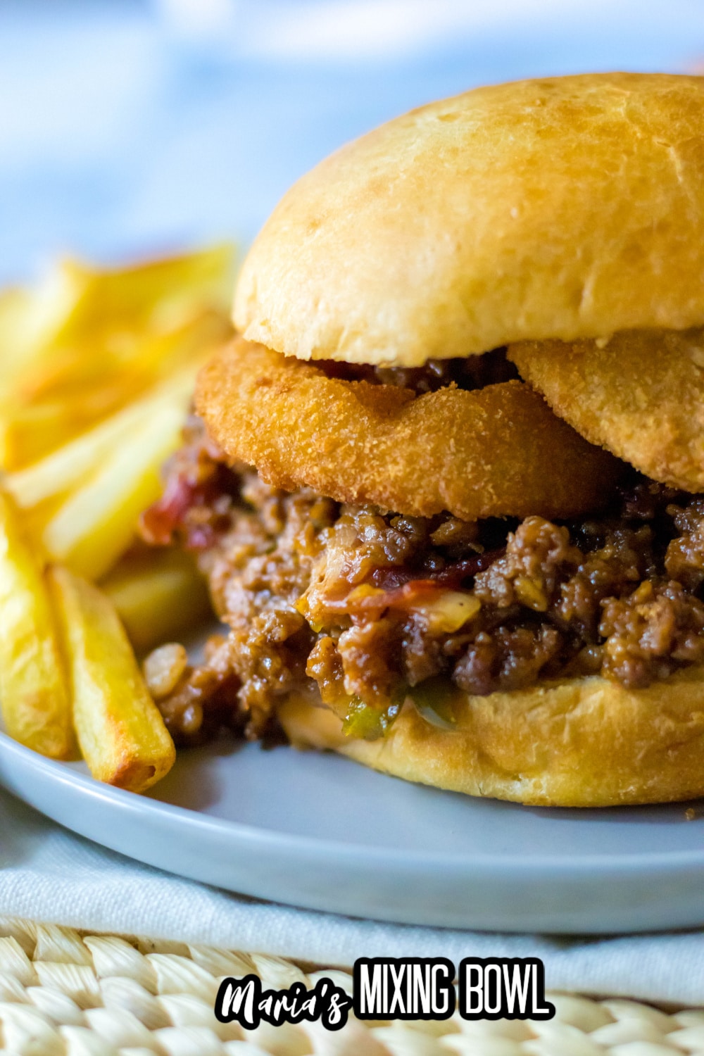 slow cooker rodeo sloppy joe on a light blue plate with french fries