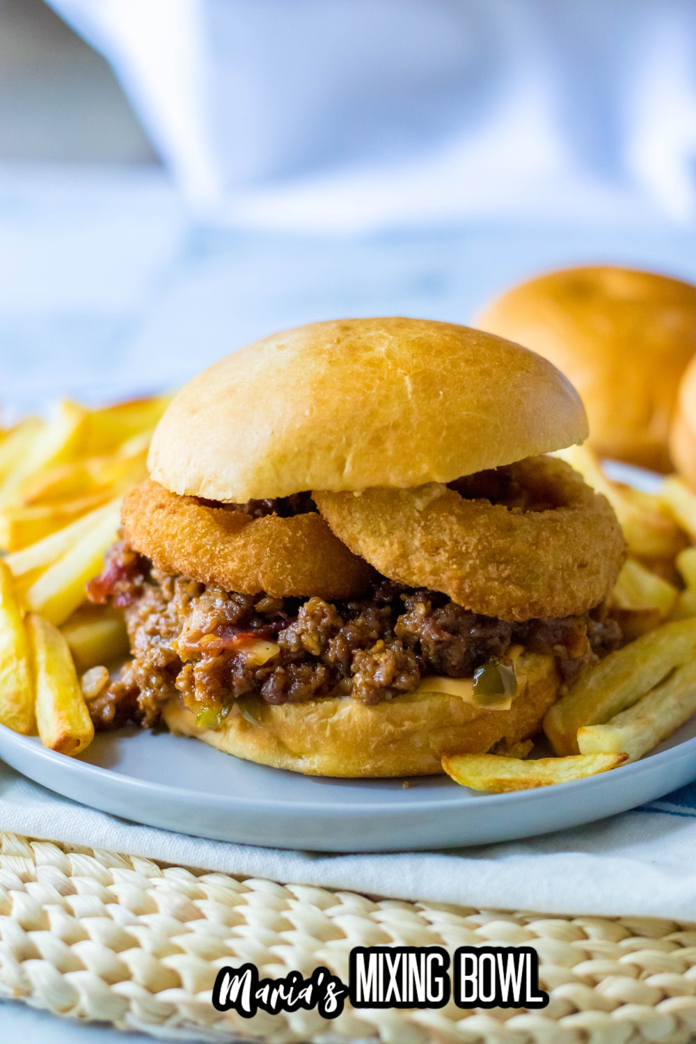 slow cooker rodeo sloppy joe on a light blue plate with french fries