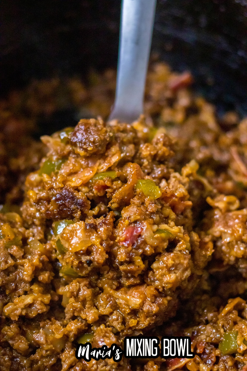 sloppy joe mixture on a metal spoon in a slow cooker liner
