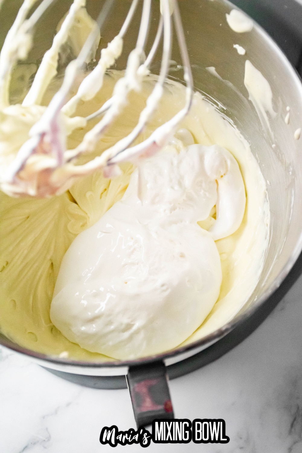 cream cheese and sour cream in a stainless steel mixing bowl