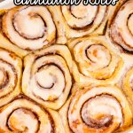 frosted cinnamon rolls in a white ceramic baking dish with the name in text for pinterest