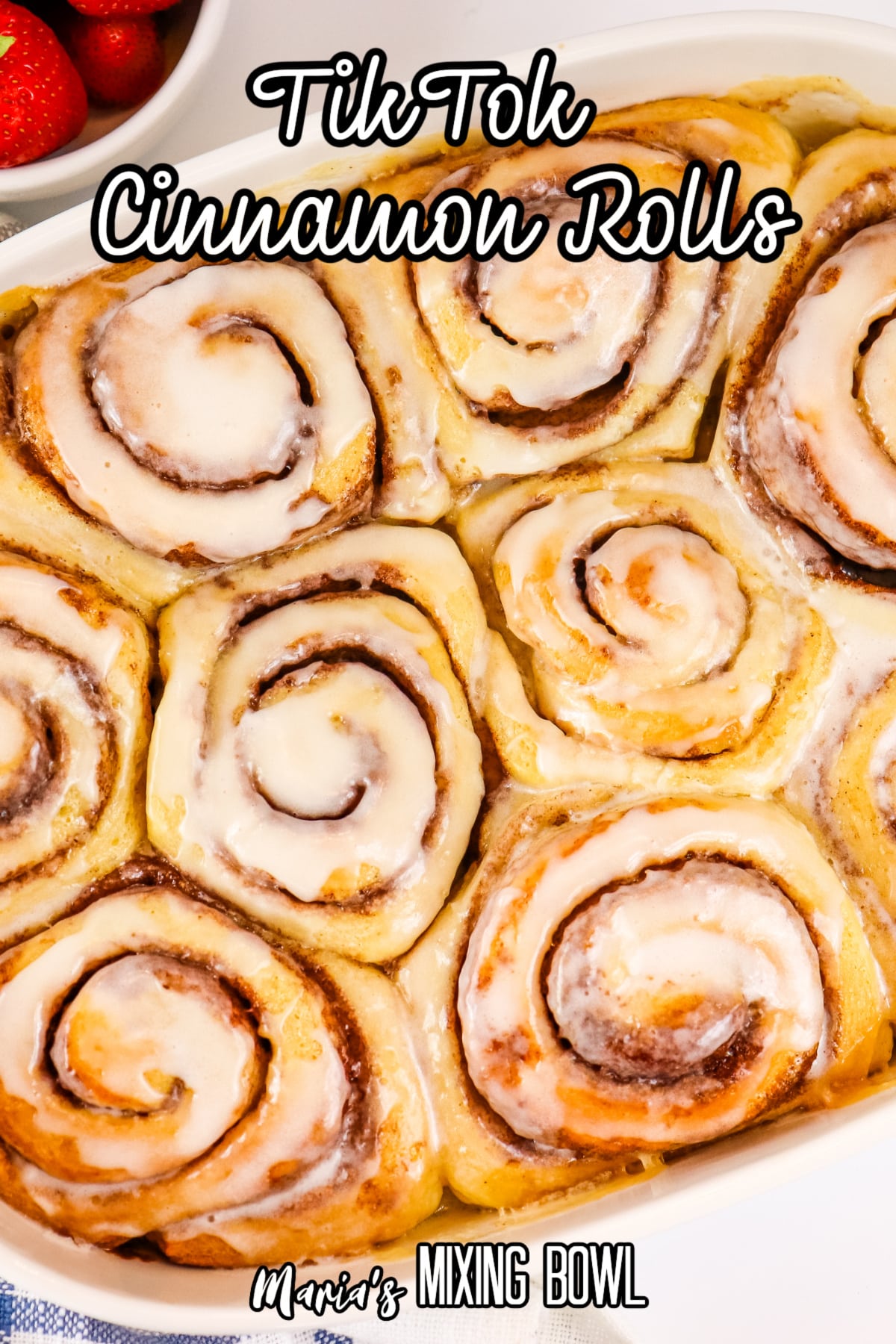 frosted cinnamon rolls in a white ceramic baking dish with the name in text for pinterest