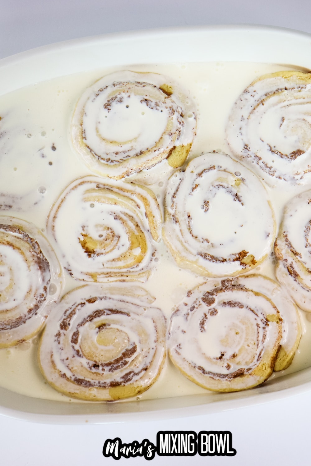 raw dough topped with heavy whipping cream in a white baking dish