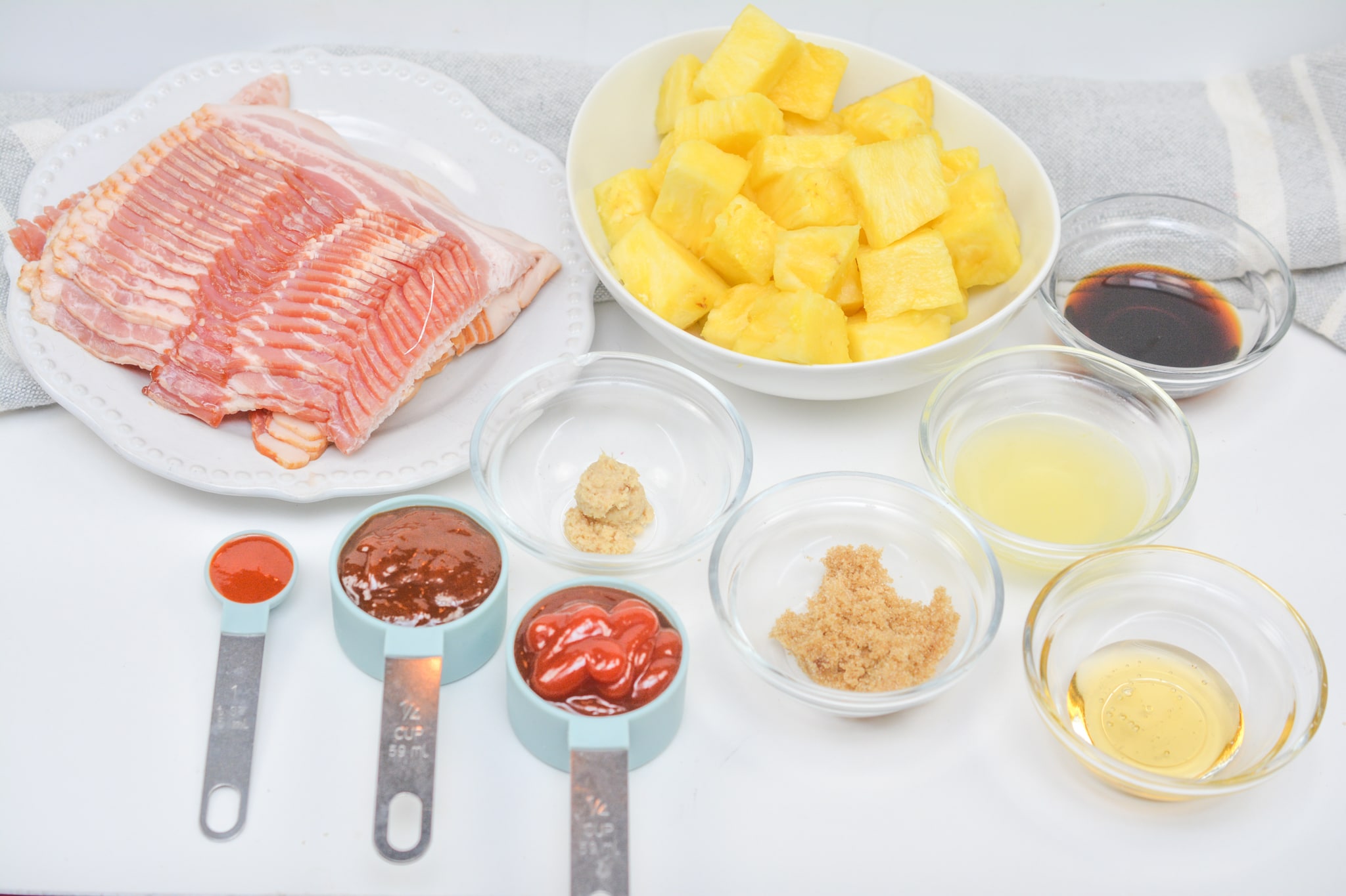ingredients for bacon wrapped pineapple on a white background
