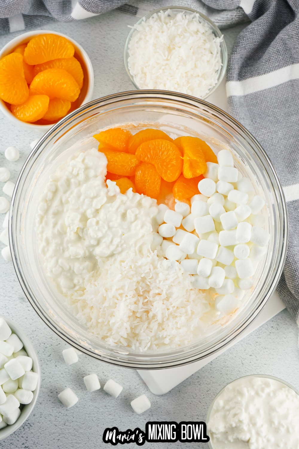 oranges, marshmallows, cottage cheese, and coconut in a glass bowl