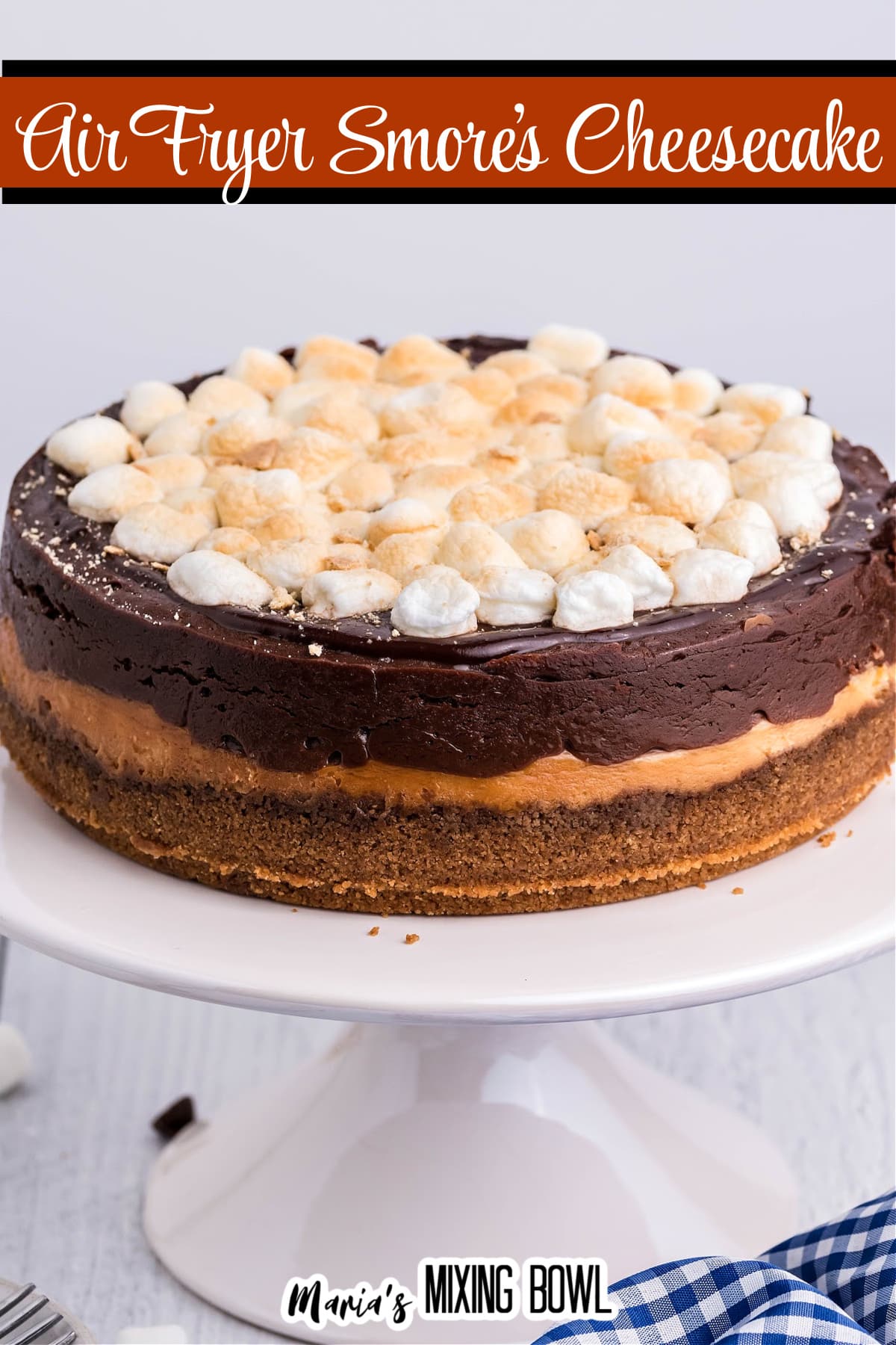 uncut air fryer smores cheesecake on a white cake stand