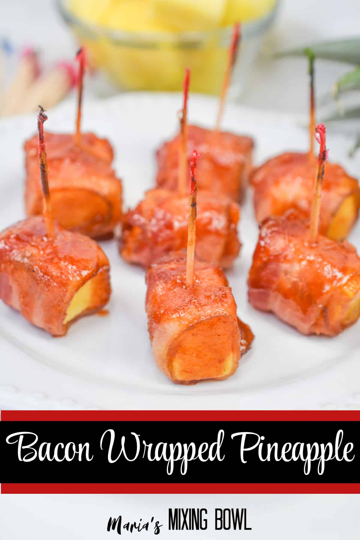 pieces of bacon wrapped pineapple on a white plate with "bacon wrapped pineapple" in text