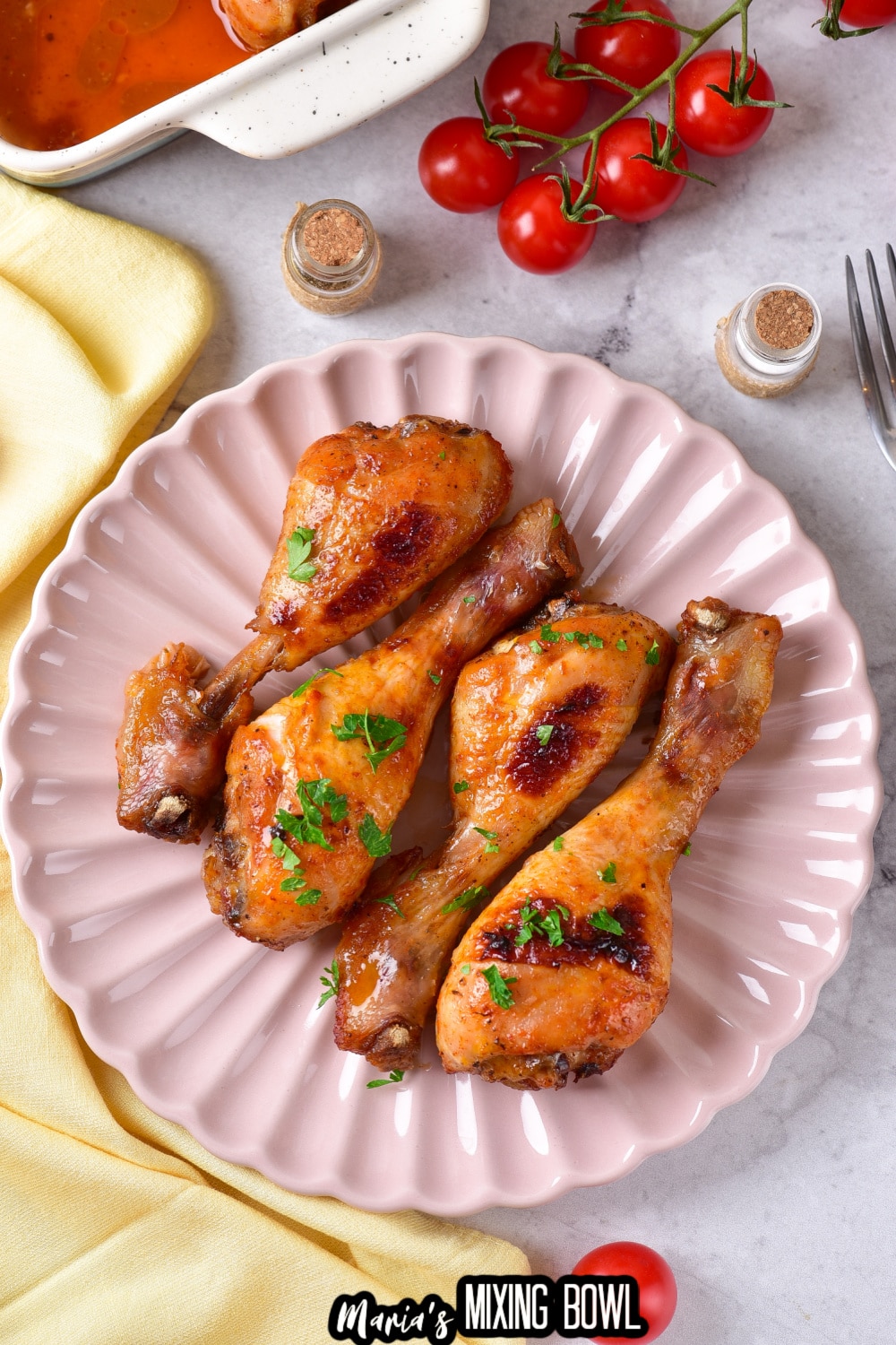 four bbq chicken legs on a light pink scalloped plate