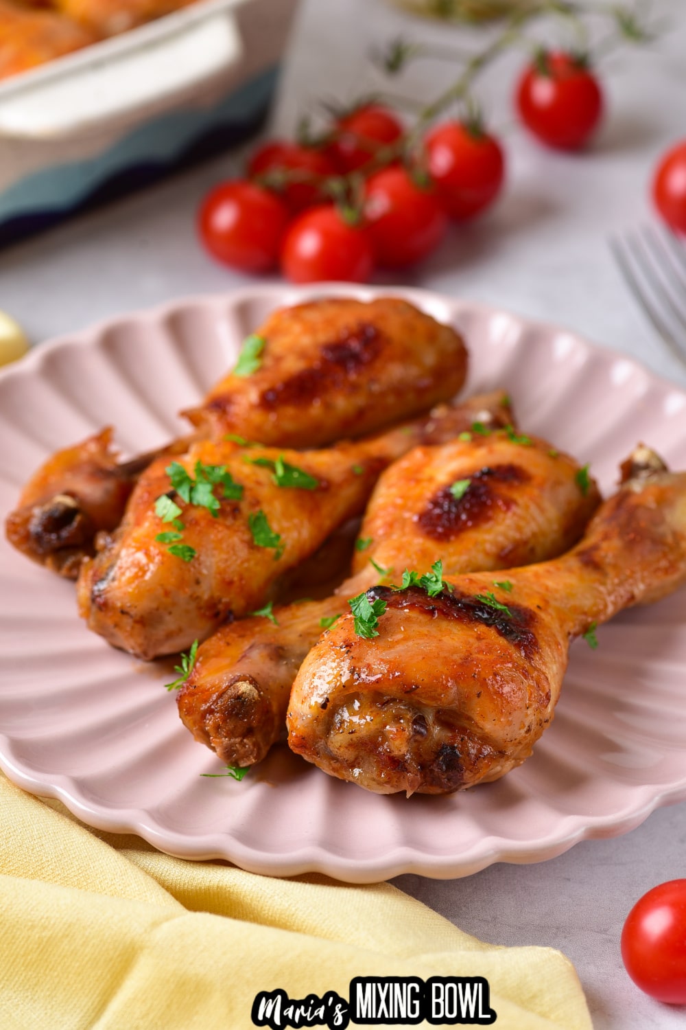 four bbq chicken legs on a light pink scalloped plate