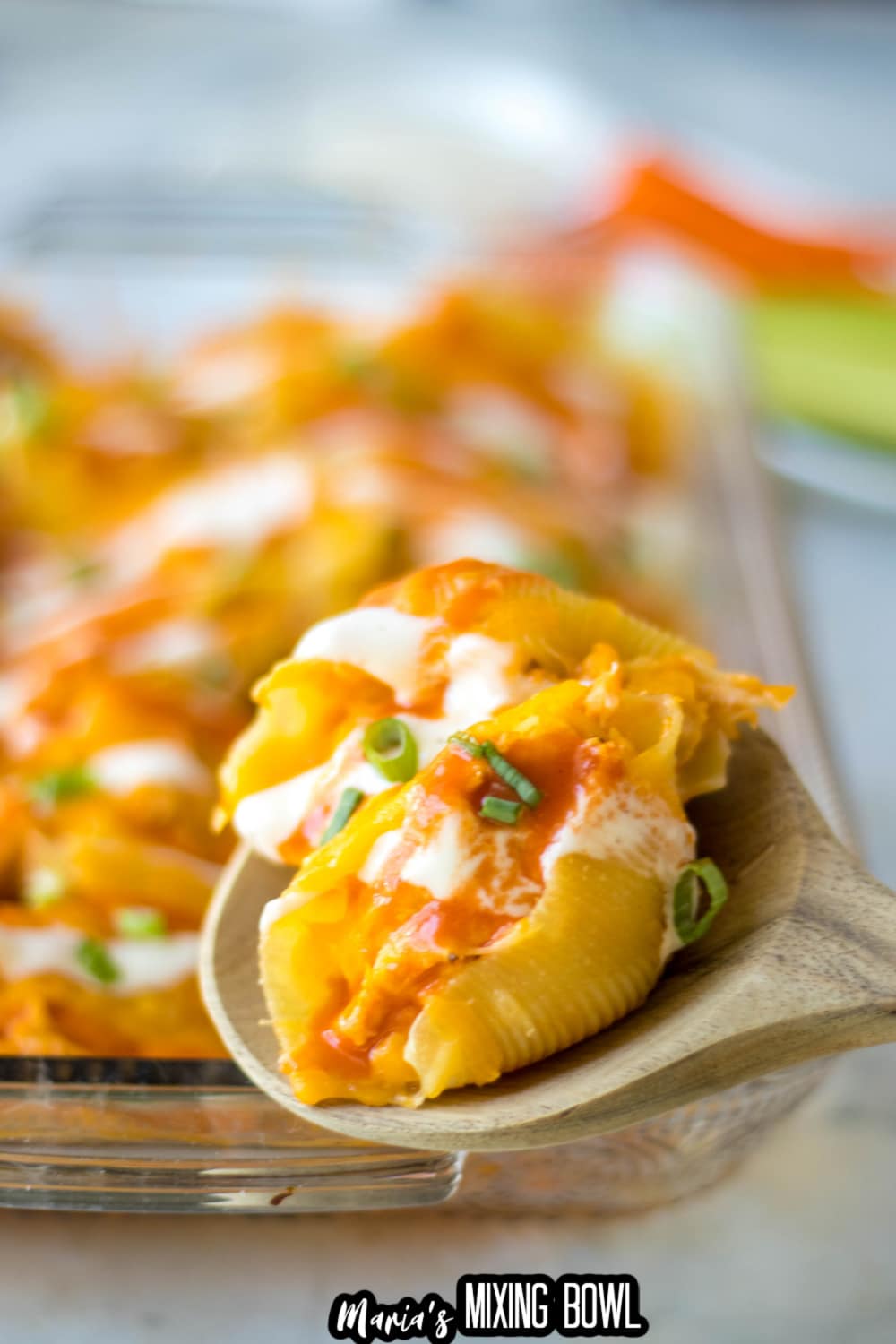 buffalo stuffed shells on a wooden spoon
