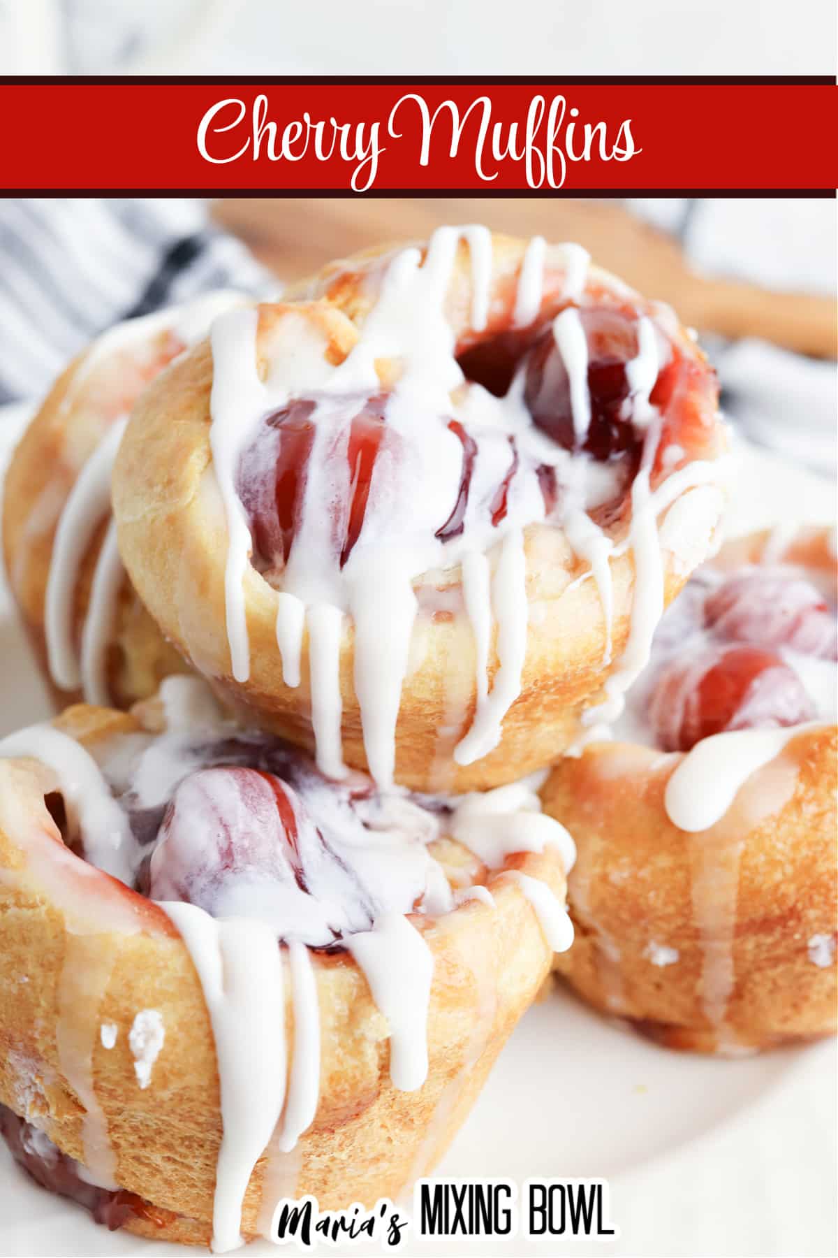 cherry muffins topped with icing, and stacked on a white plate