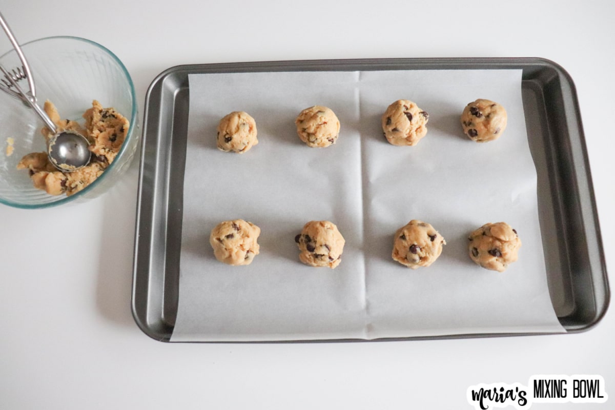 cookie dough balls on a parchment lined baking sheet