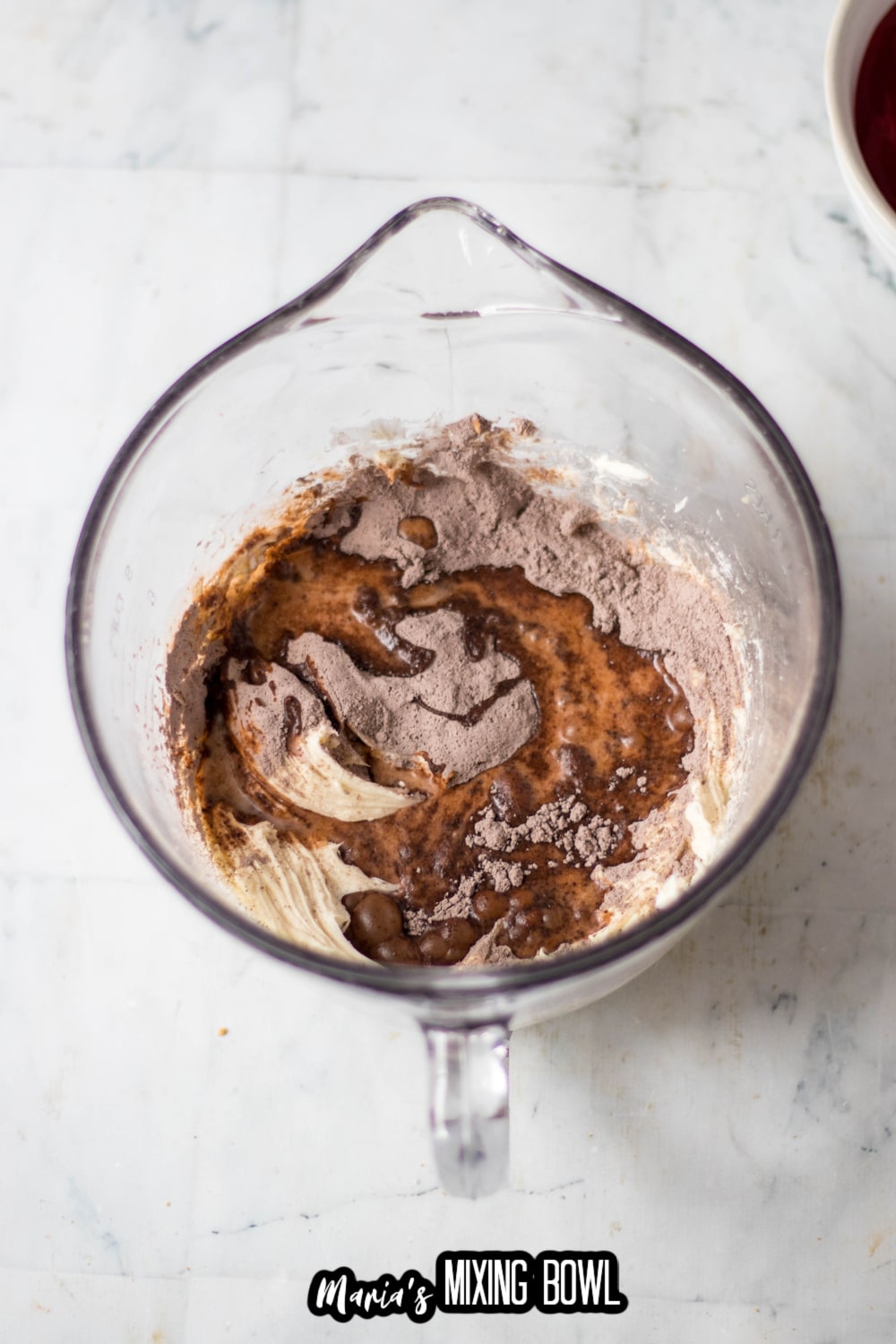 cream cheese and chocolate pudding being mixed in a glass mixing bowl