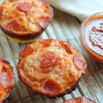 deep dish pizza bites on a wire cooling rack with a small bowl of pizza sauce on the side