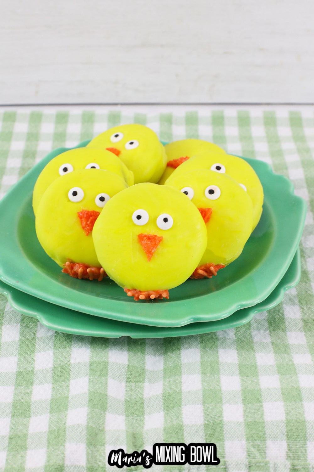 seven easter chick oreos on a green and white checkered napkin