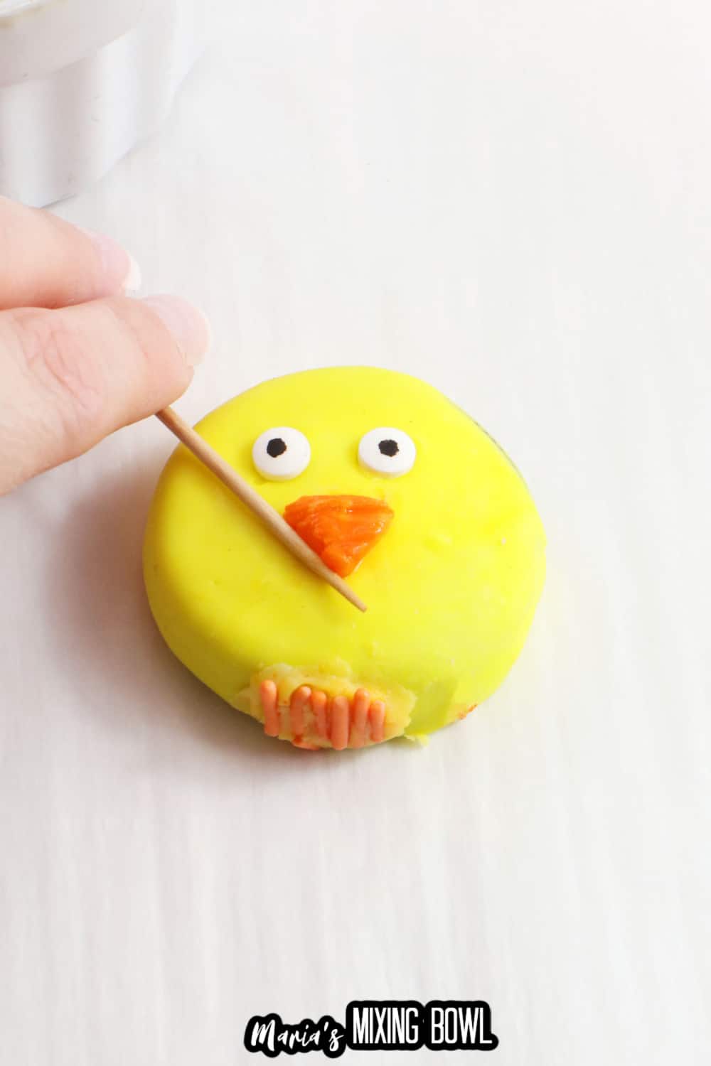 beak being shaped onto a cookie with a toothpick