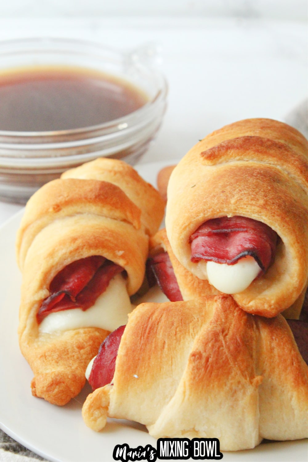 stack of french dip crescents on a white plate