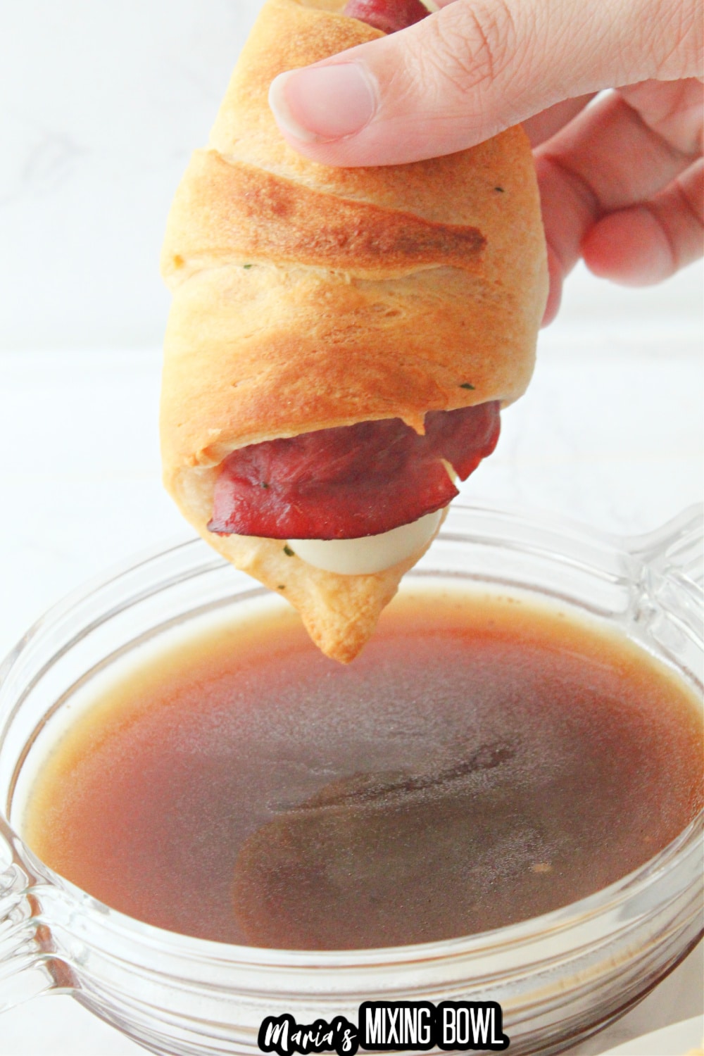 french dip crescent being dipped in au jus