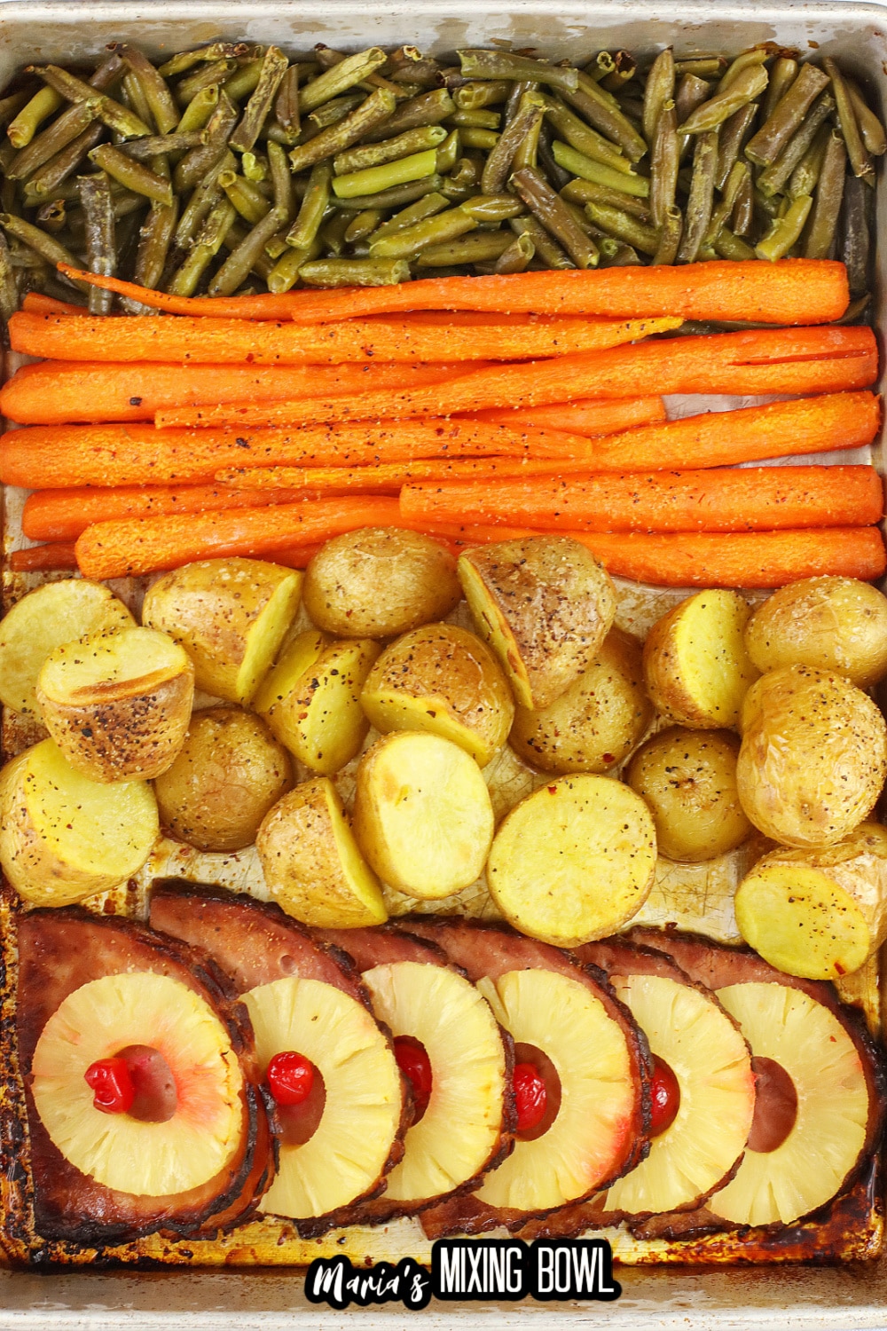green beans, carrots, potatoes and ham on a baking sheet