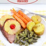 close up of ham, carrots, green beans, and potatoes on a white plate