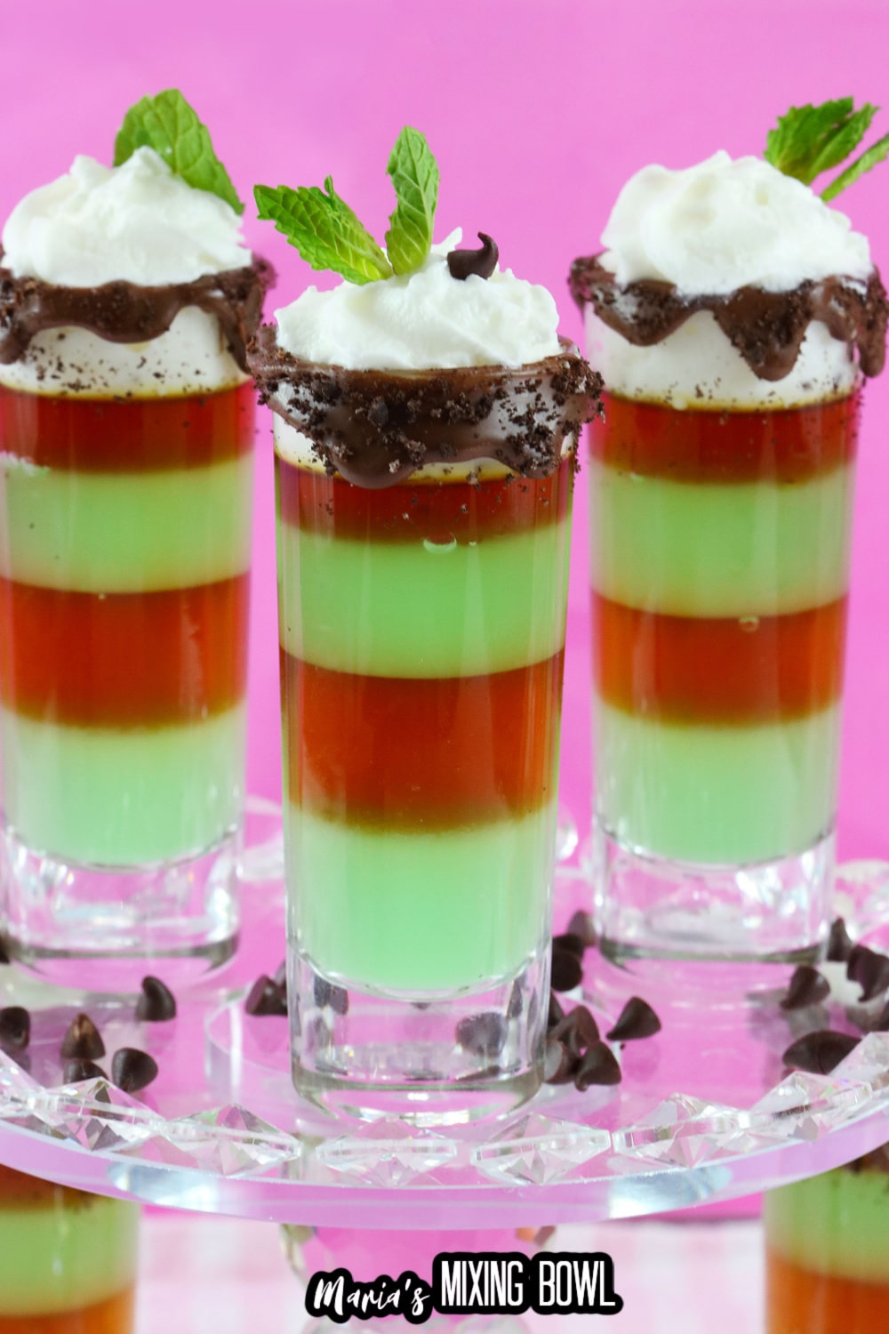three mint shots on a clear glass cake stand