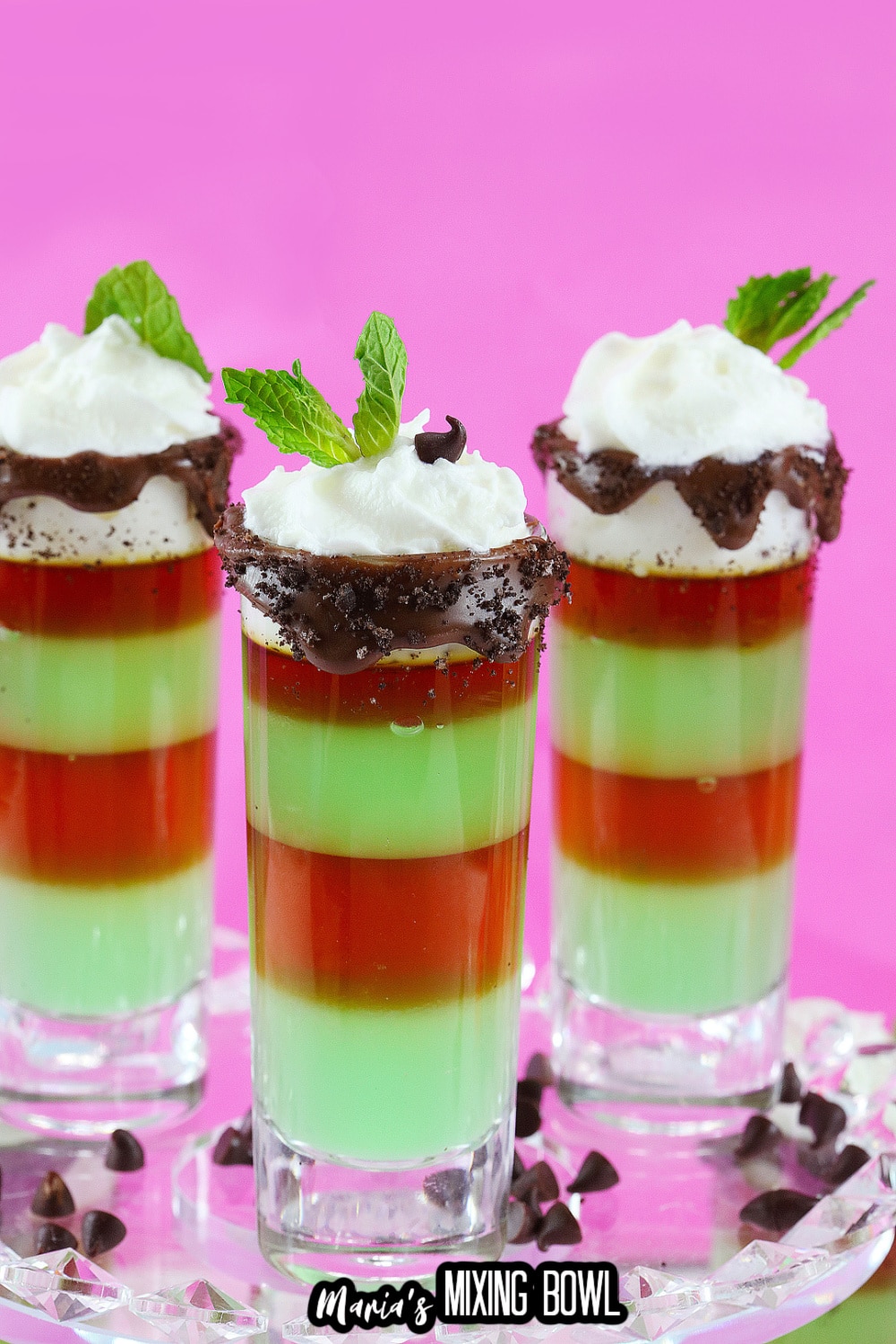 three mint shots on a clear glass cake stand