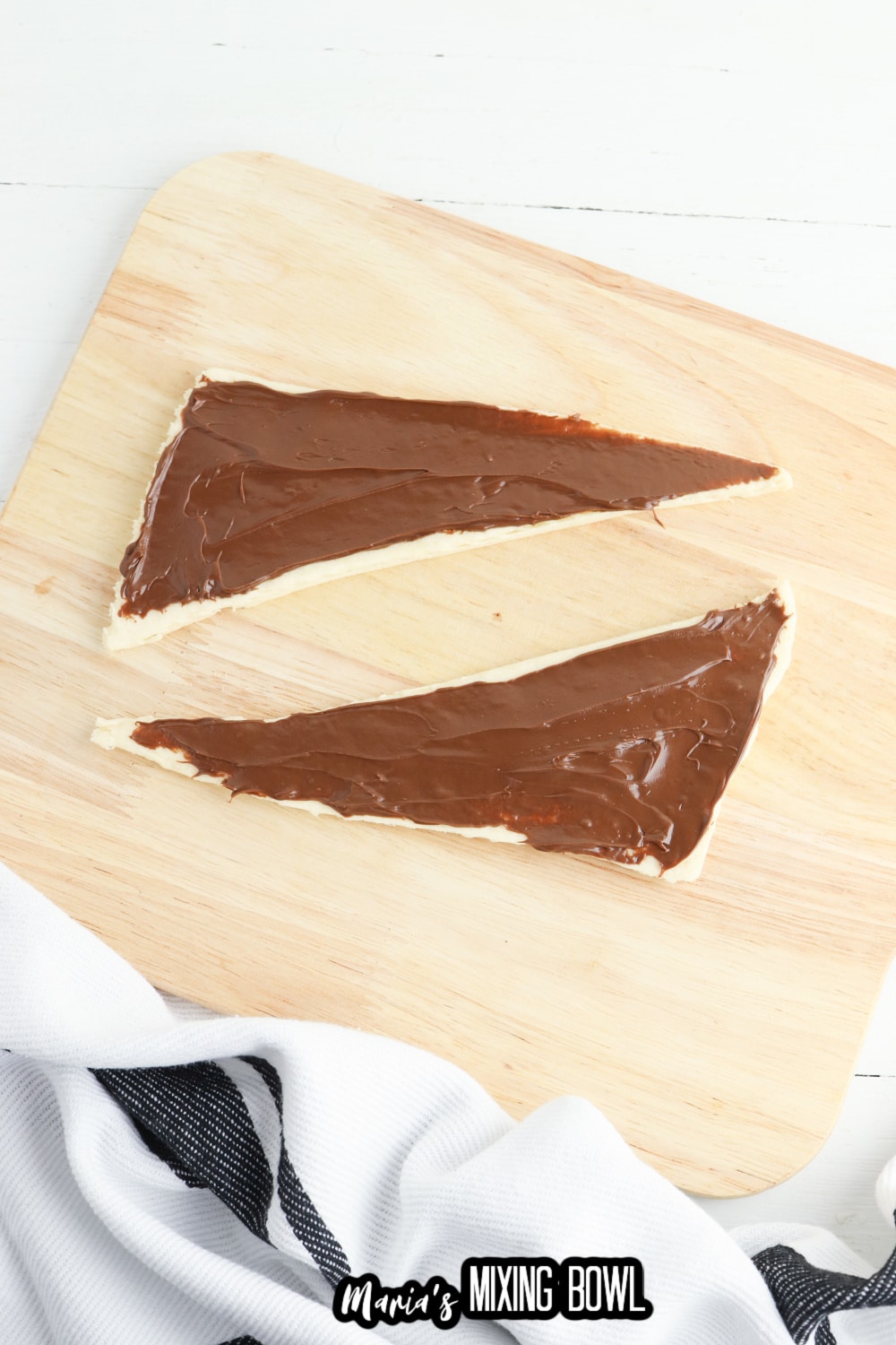 nutella being spread on top of dough
