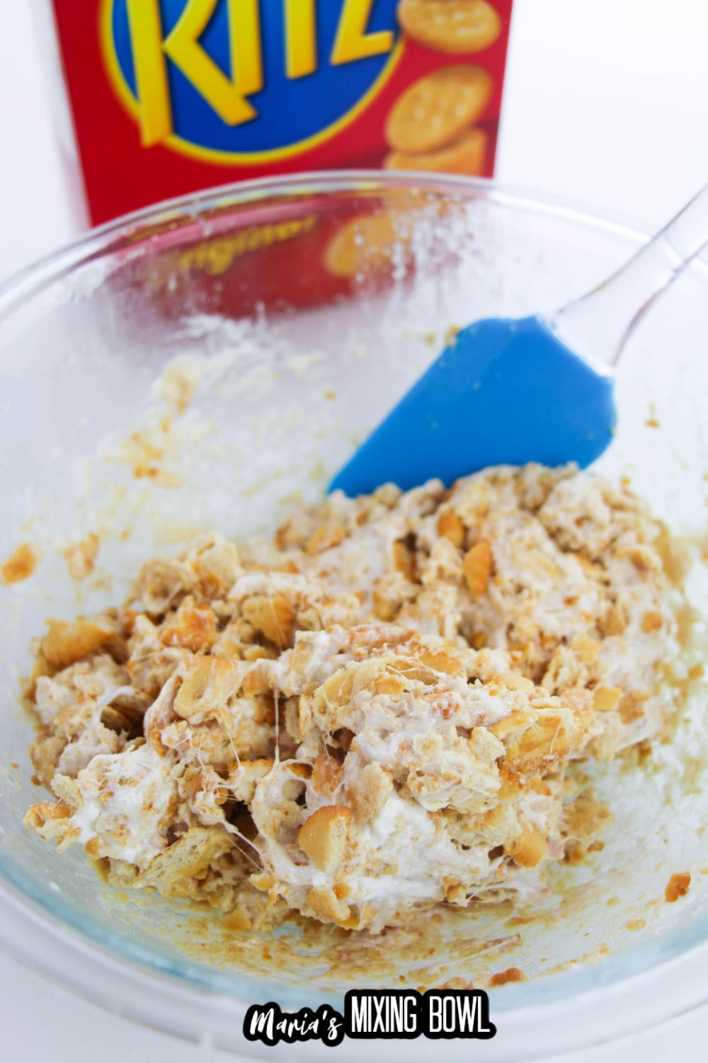 ritz crackers and melted marshmallows being mixed in a glass bowl